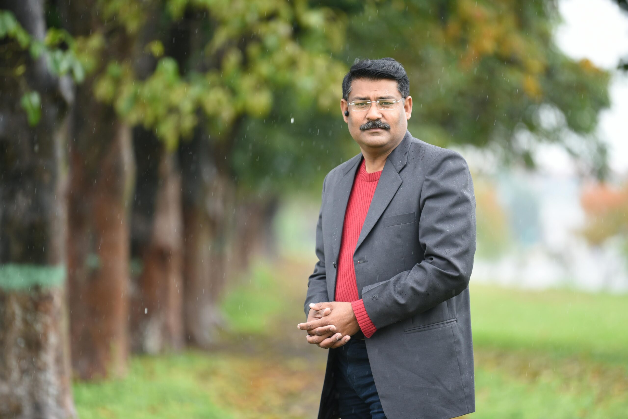 Home Portrait of a smiling man outdoors in Islamabad, Pakistan, on a rainy day.