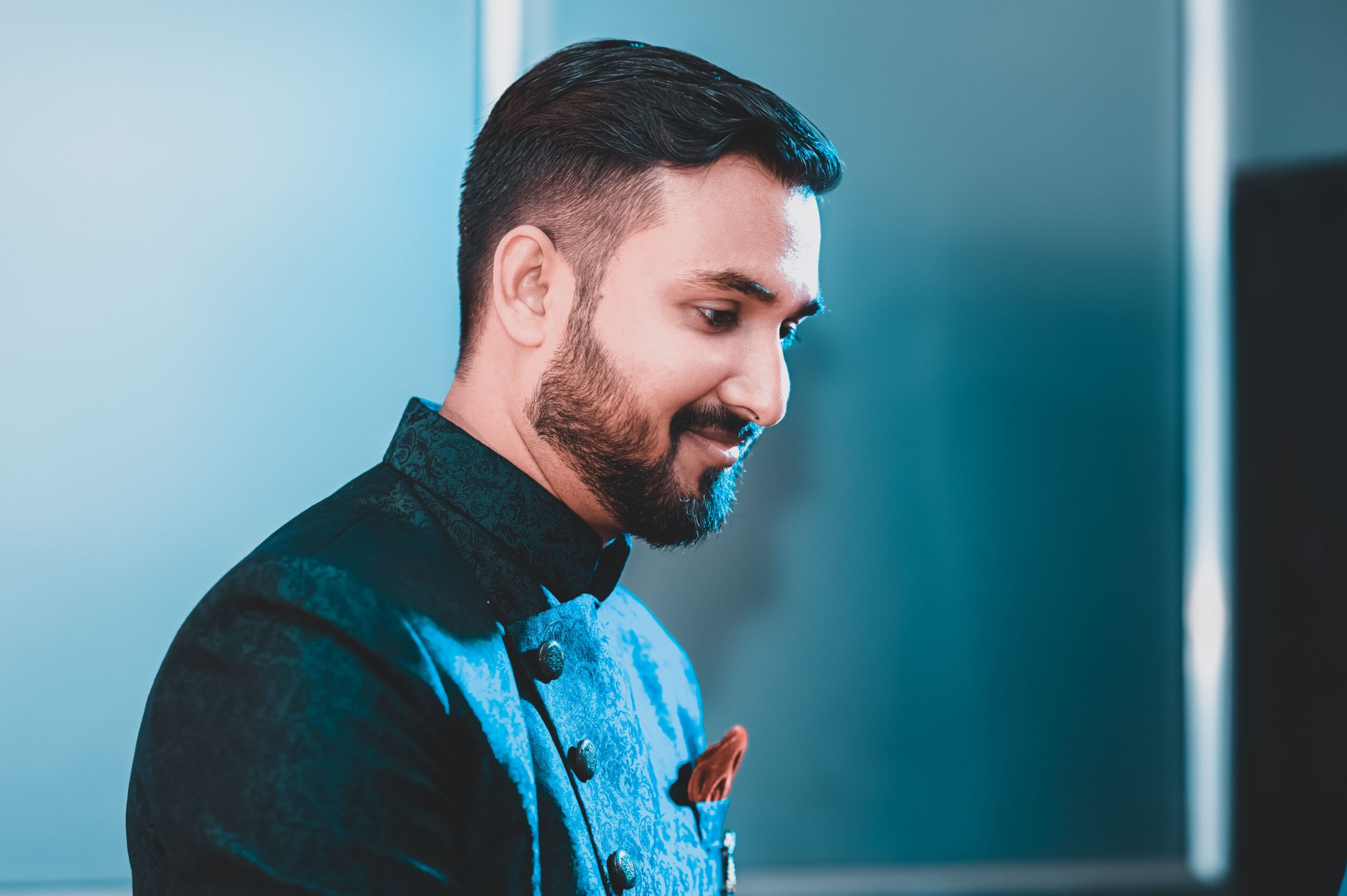 Home Elegant portrait of a bearded man smiling in formal attire, highlighting details and mood.